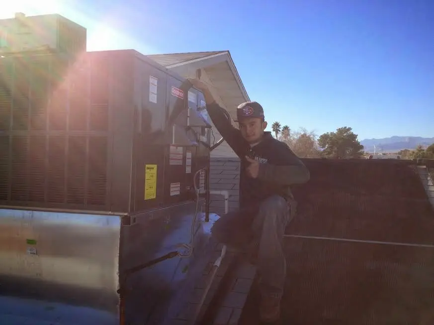 HVAC technician performing Boiler Repair on a rooftop unit in Vermillion
